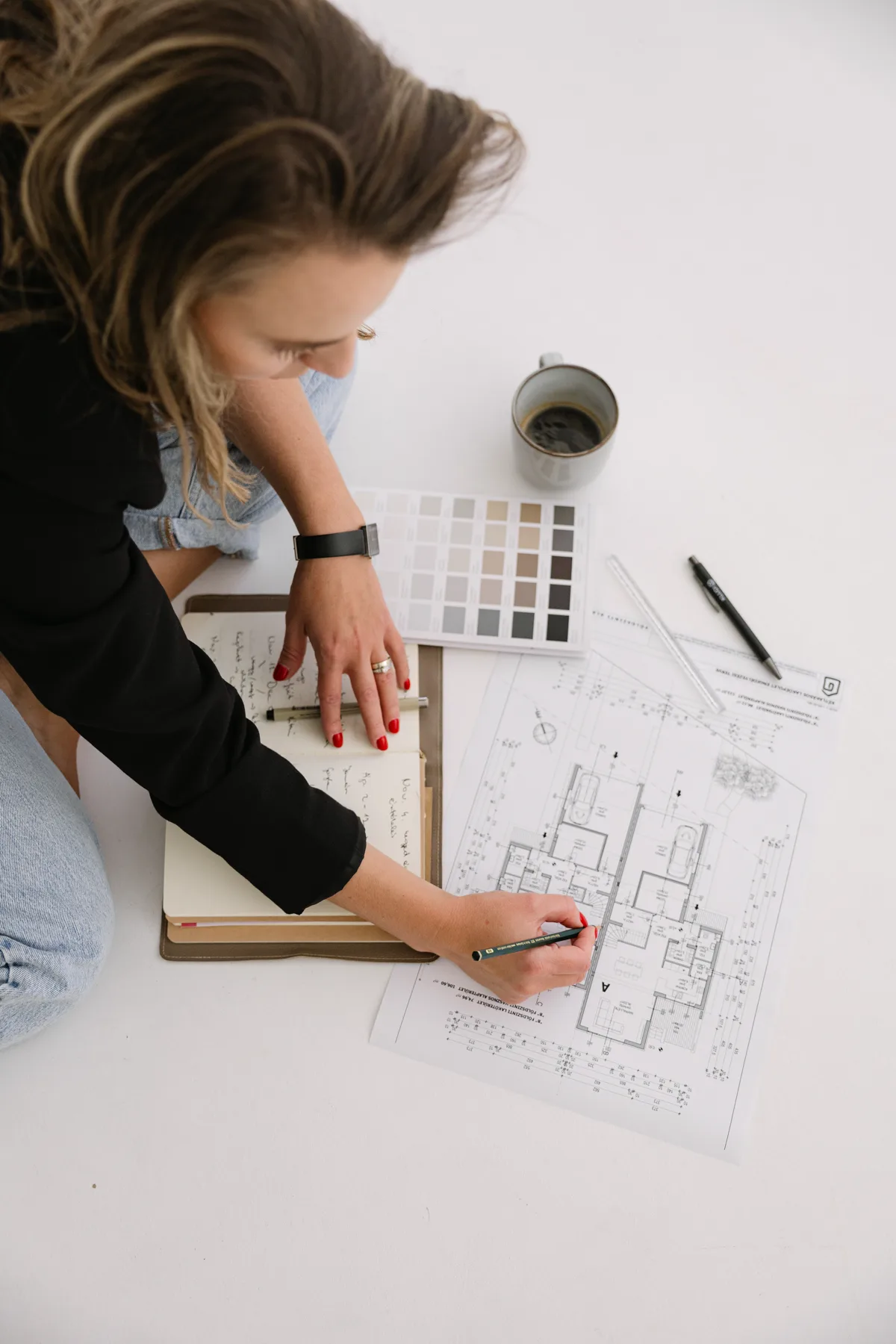 Adrienn Beck planning over floor plans and a color palette